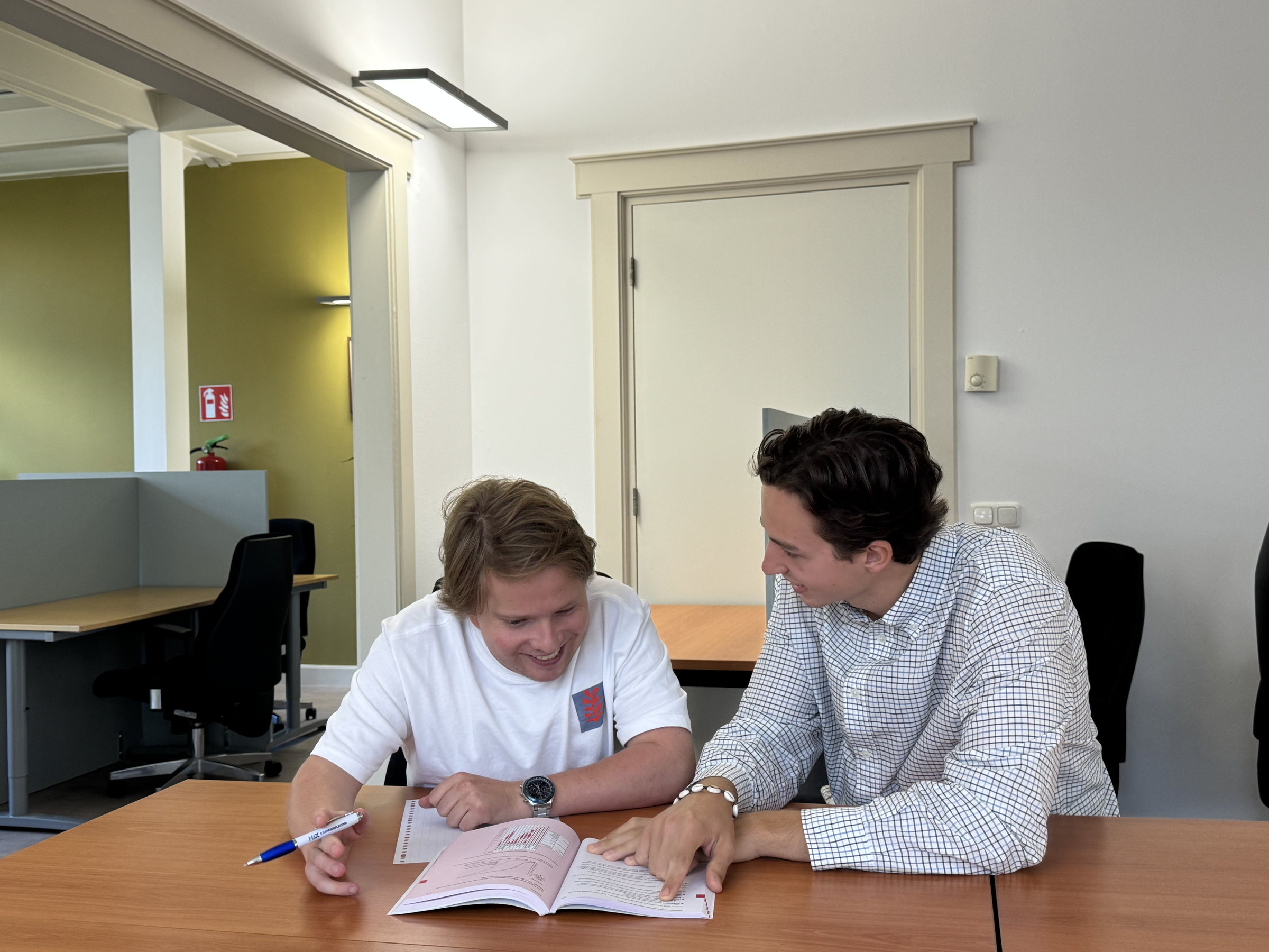 Begeleider en leerling werken samen in een schoolboek