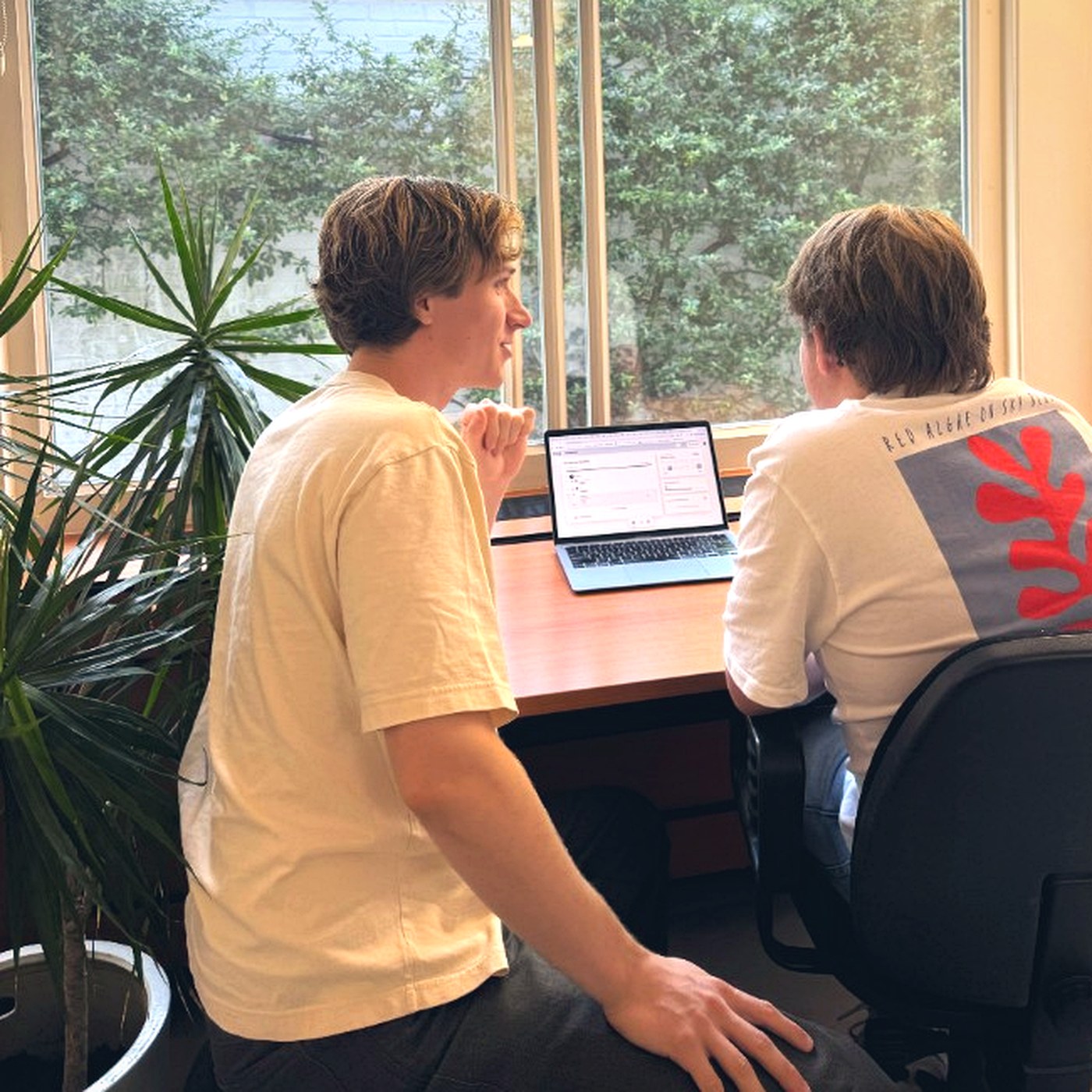 Begeleider en leerling bekijken samen de planning op een laptop